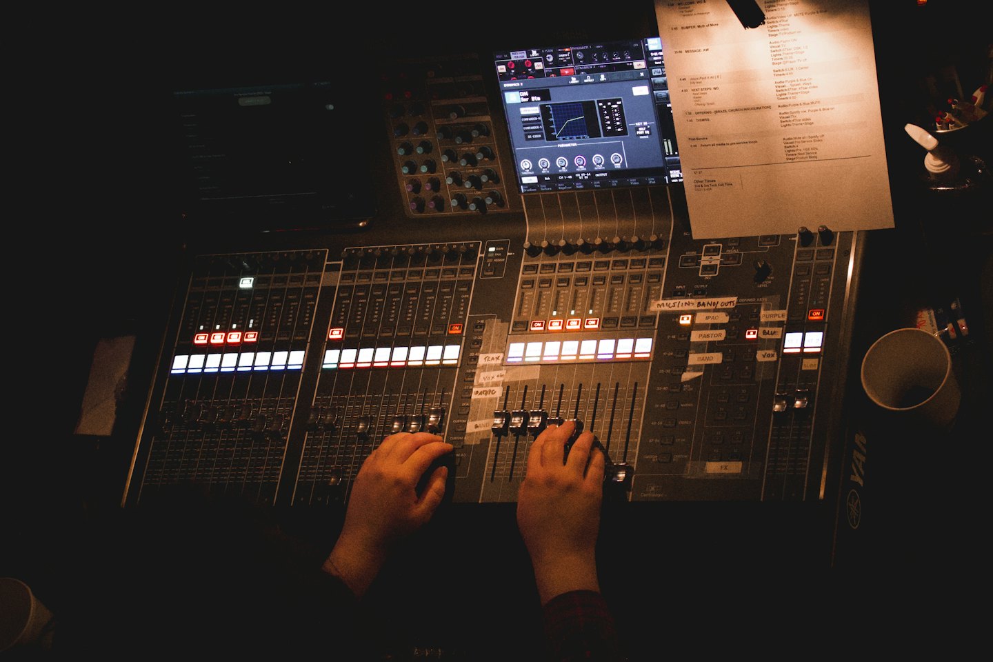 Ingegnere del suono che mixa audio su una grande console digitale.