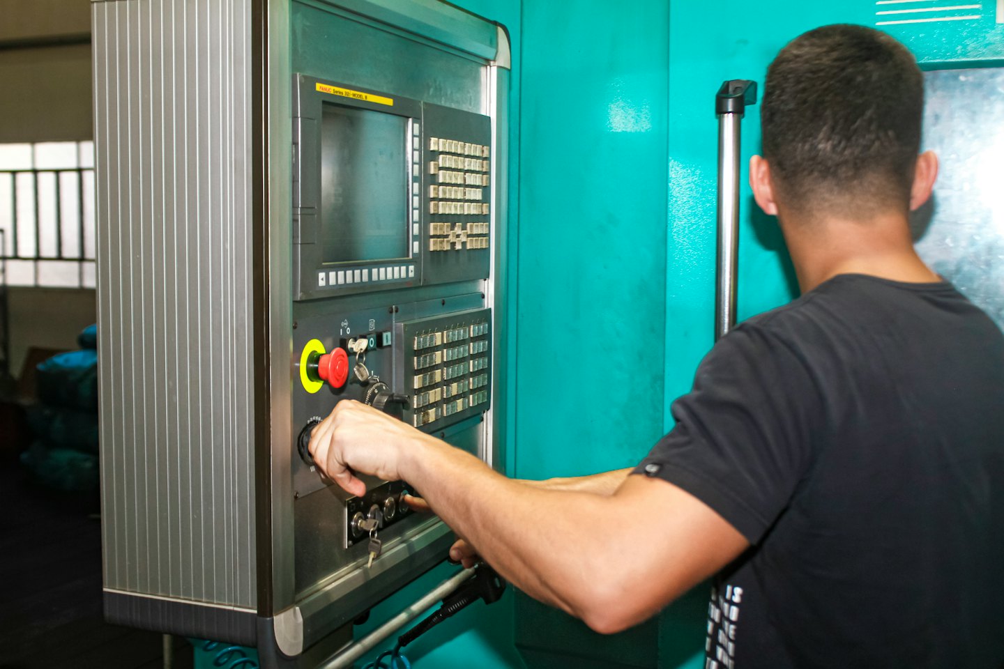 Mani che azionano un pannello di controllo di una macchina industriale.
